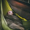 man lying in need.for.trees production hammock, with nft quilt, lying diagonally in hammock